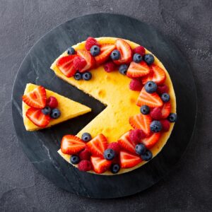 Cheesecake dessert with fresh berries. Gray background. Close up. Top view.