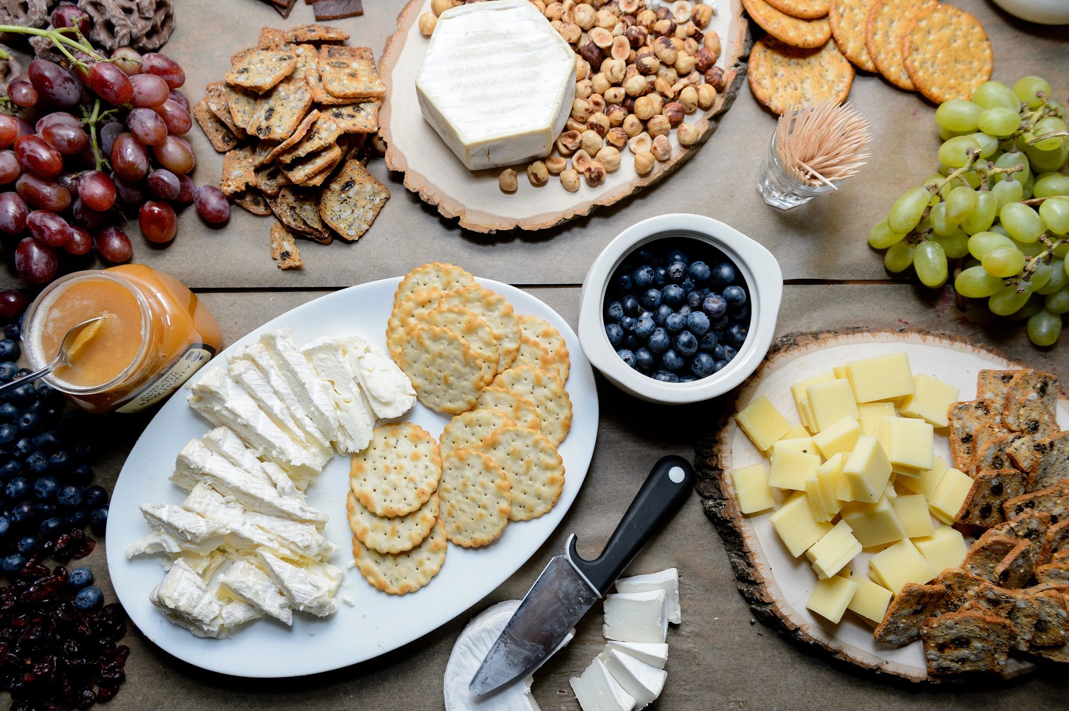 Tabla de aperitivos con frutas, quesos y crackers para compartir